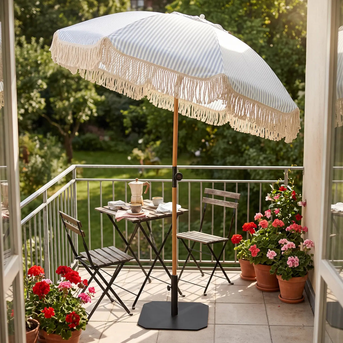 Malibu Parasol Ø1.8 m with Tilt standing in a black base over a bistro set on a balcony