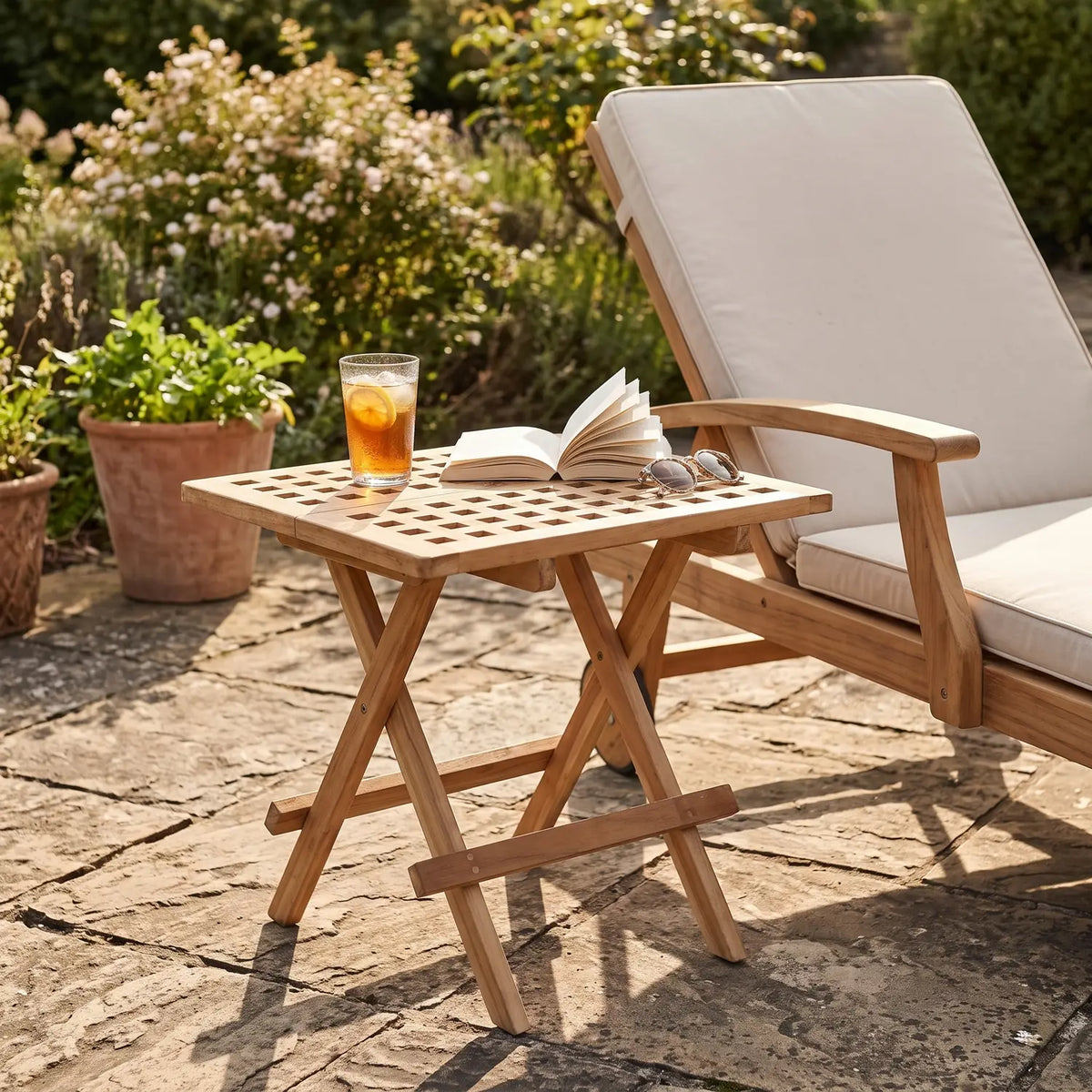 Folding Slatted Teak Table 50 x 50 cm beside a teak sun lounger